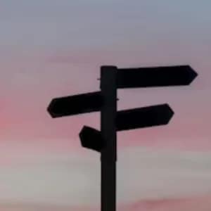Directional signpost pointing in multiple directions at sunset
